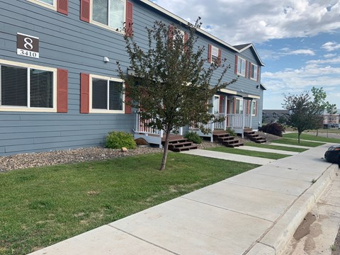 a blue house with a sidewalk in front of it