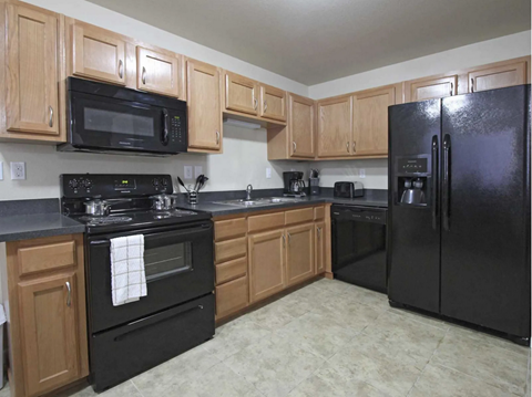 a kitchen with black appliances and wooden cabinets