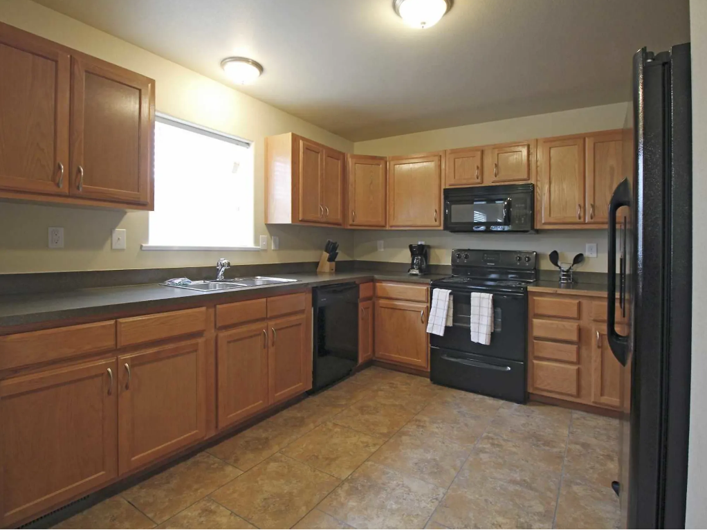 a kitchen with black appliances and wooden cabinets