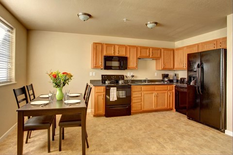 a kitchen with wooden cabinets and a table with chairs