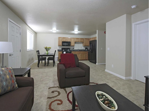an open living room and kitchen with a table and chairs