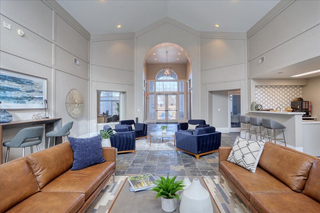 a living room with couches and chairs and a kitchen
