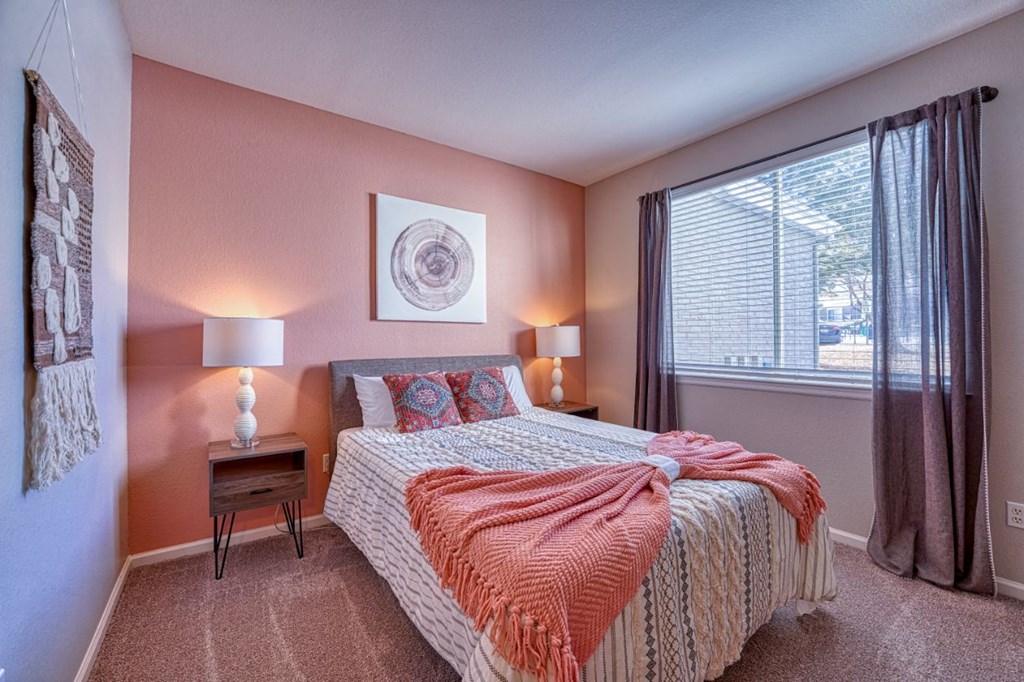 a bedroom with a bed and a large window