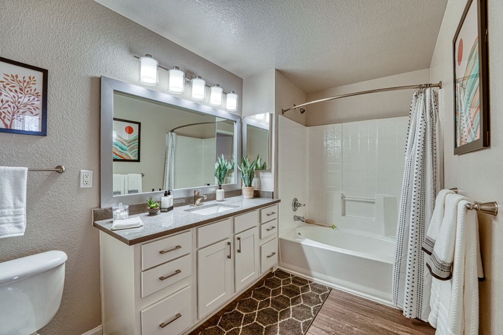 a bathroom with a large mirror and a tub and a sink