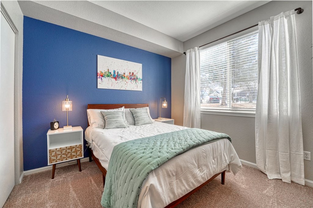 a bedroom with a bed and a large window