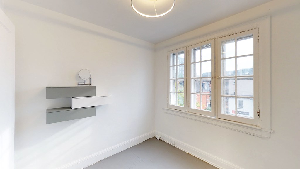 a living room with a large window and white walls