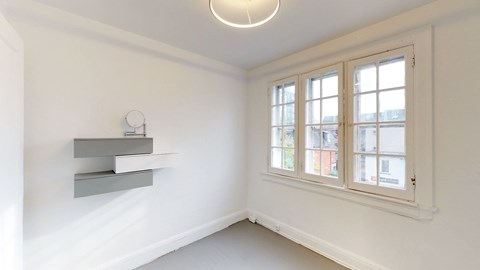a living room with a large window and white walls