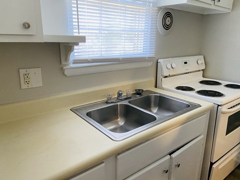 a kitchen with a sink and stove and a window