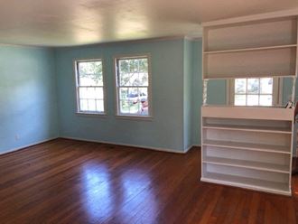 an empty room with blue walls and a wooden floor
