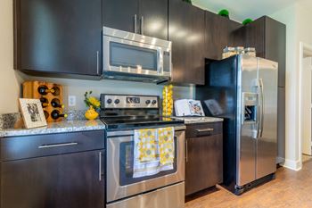 Kitchen with appliances and wooden floorat Prairie Creek Apartments & Townhomes, Kansas, 66219