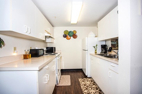 a kitchen with white cabinets and a sink and a refrigerator