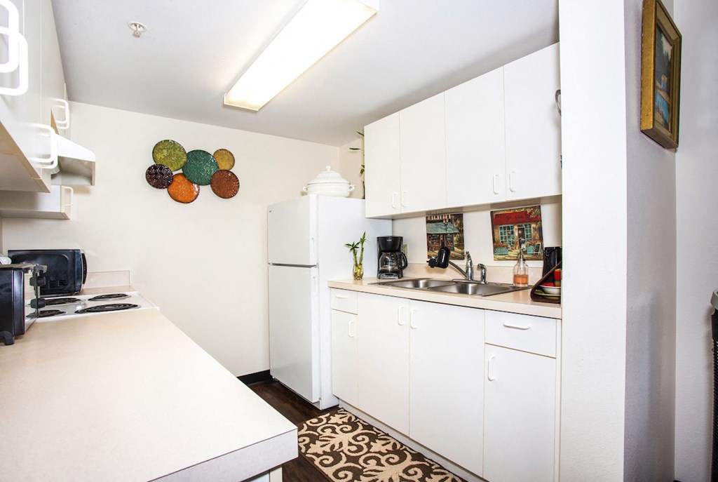 kitchen with white cabinets, appliances, and stainless steel double sink