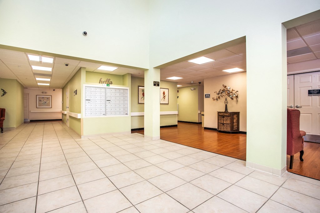 lobby of Villa Vincente with tile & wood-style floor and mailbox bank in wall