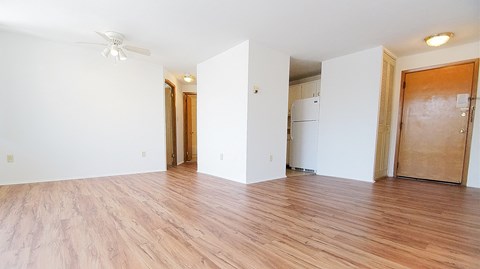 an empty living room with white walls and wood flooring