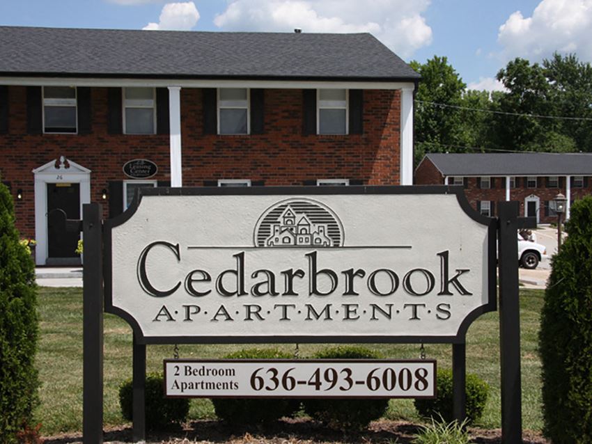 a sign for cedarbrook apartments in front of a building
