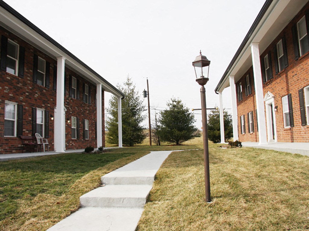 a sidewalk in front of a brick building