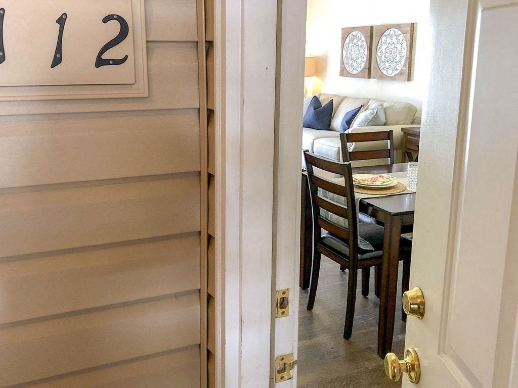 a view through a door into a dining room with a table and chairs