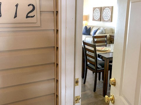 a view through a door into a dining room with a table and chairs