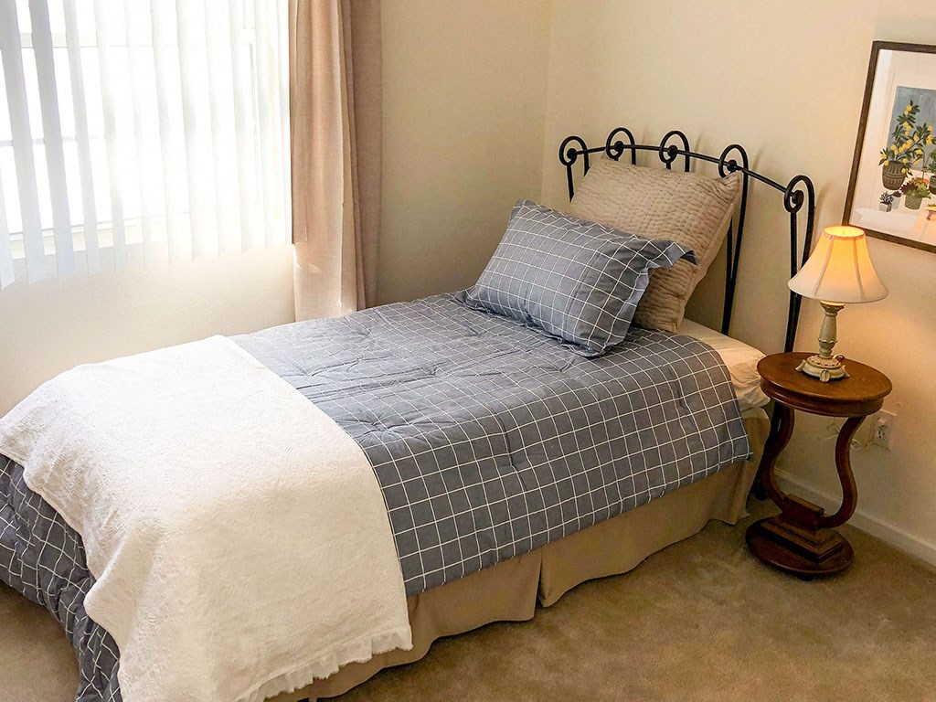 a bedroom with a bed and a table with a lamp