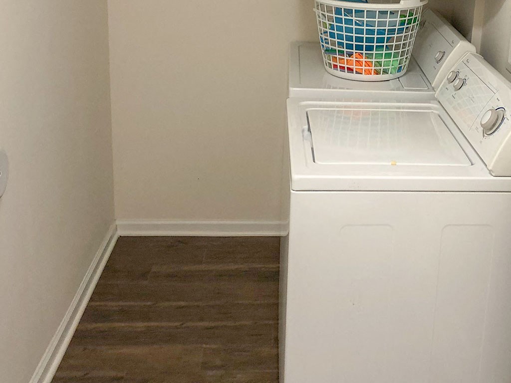 a white washer and dryer in a room with a wooden floor