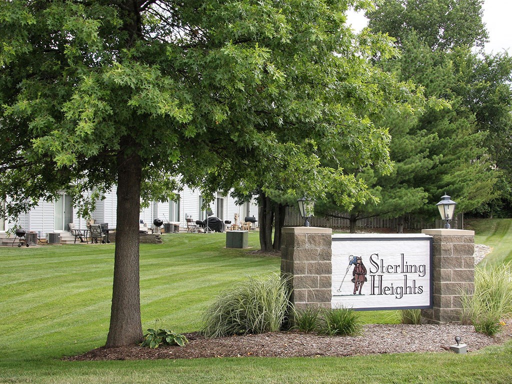 a sign for sleeping heights in front of a lawn and trees