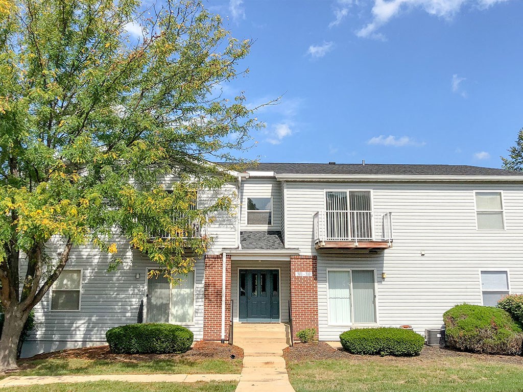 a white house with a tree in front of it