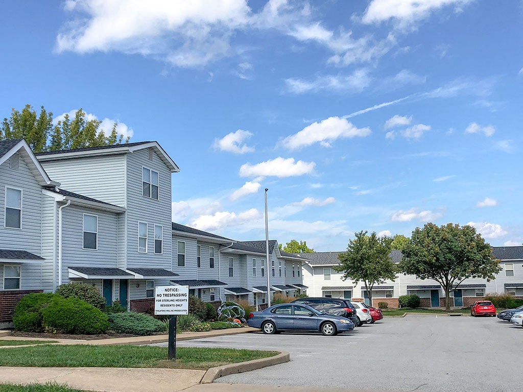 a parking lot with cars parked in front of houses