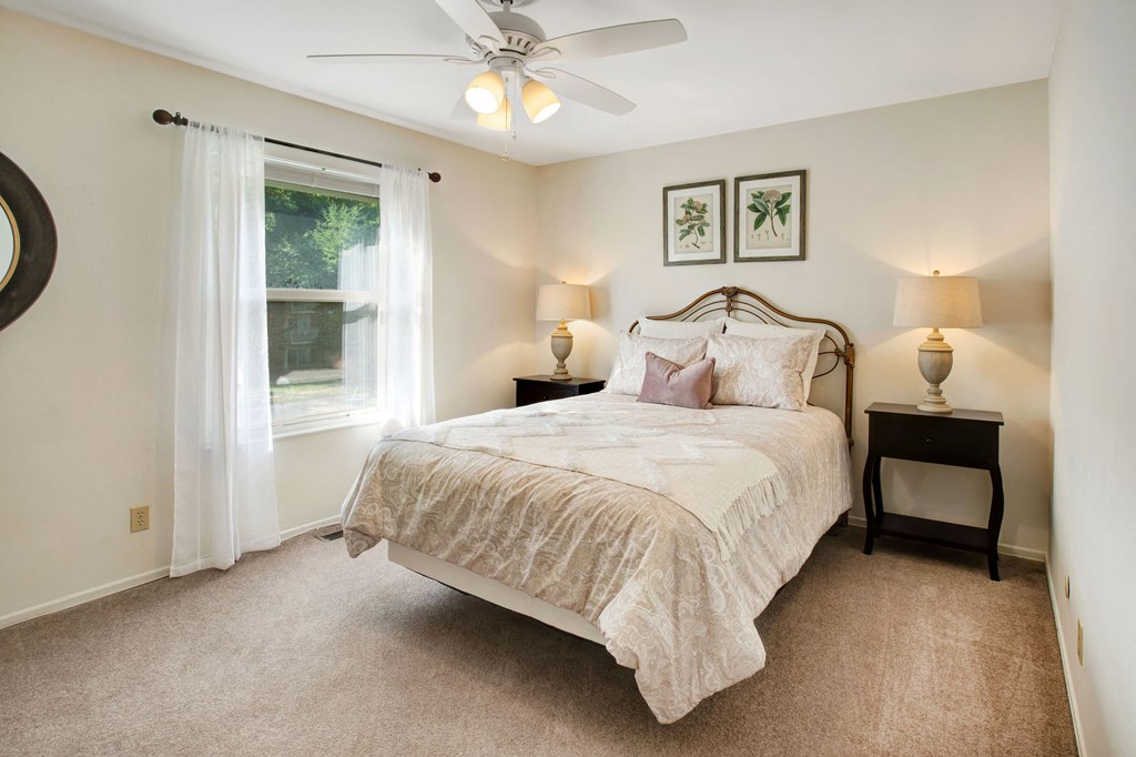 a bedroom with a bed and a ceiling fan
