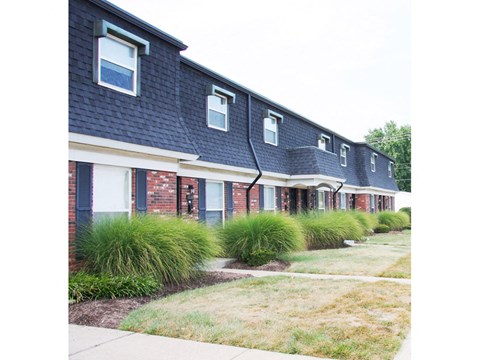a row of houses with blue roofs and a sidewalk