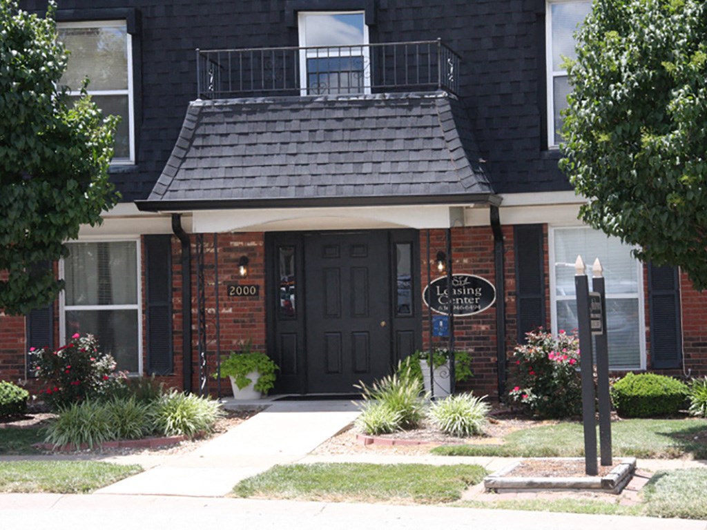 a house with a black door and a sign in front of it