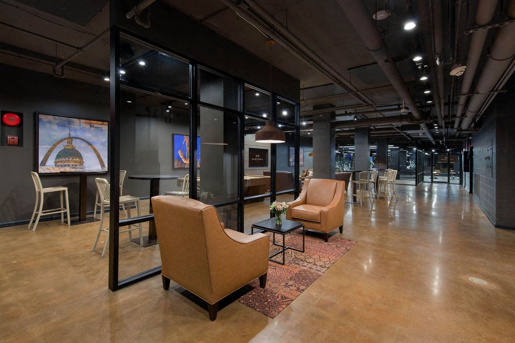 a large lobby with chairs and tables and glass walls