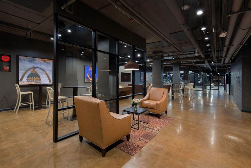 a large lobby with chairs and tables and glass walls