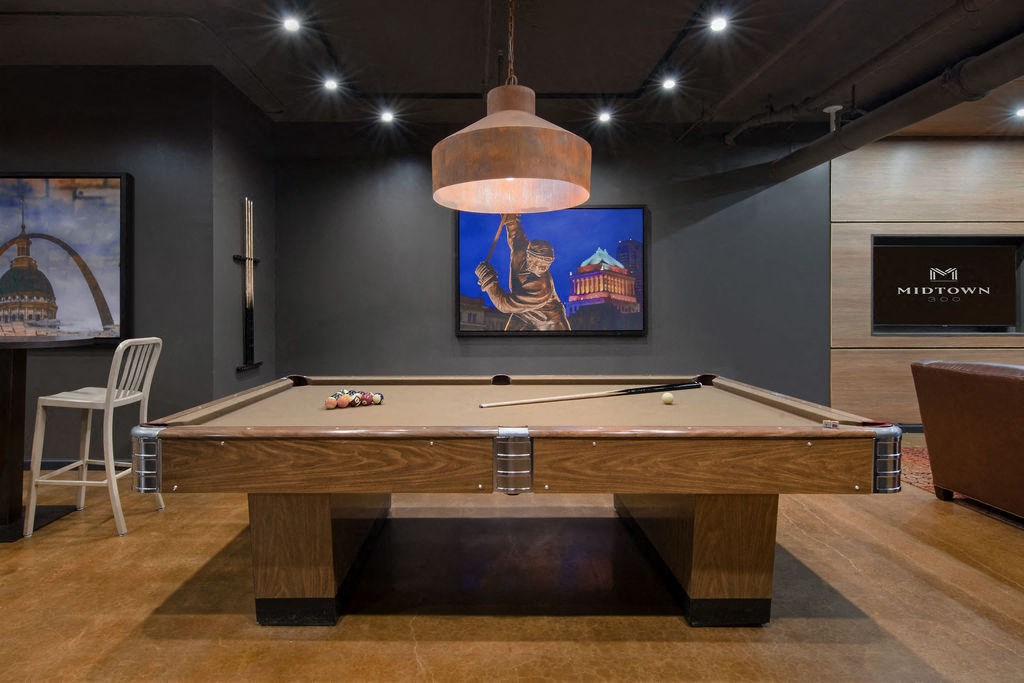 a pool table in a game room with a bar