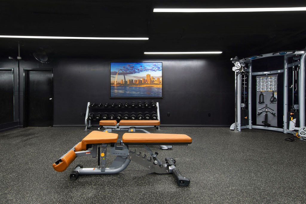a home gym with weights and a tv on the wall