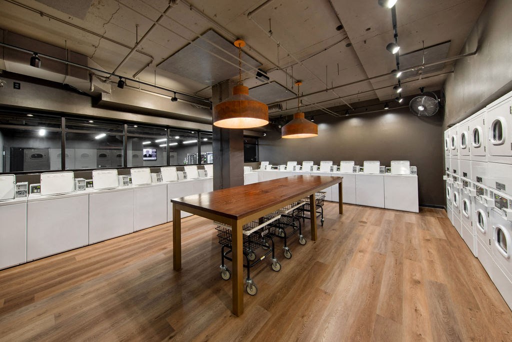 a large room with a long table and laundry machines