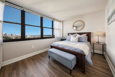 a bedroom with a large window and a bed