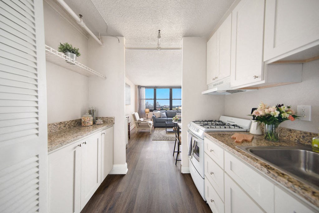 a kitchen with white cabinets and counter tops