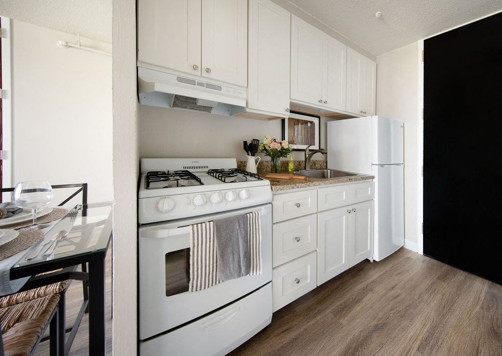 a kitchen with white cabinets and a white stove and refrigerator