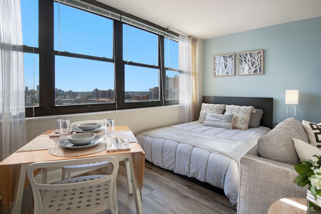 a bedroom with a bed and a table and a window