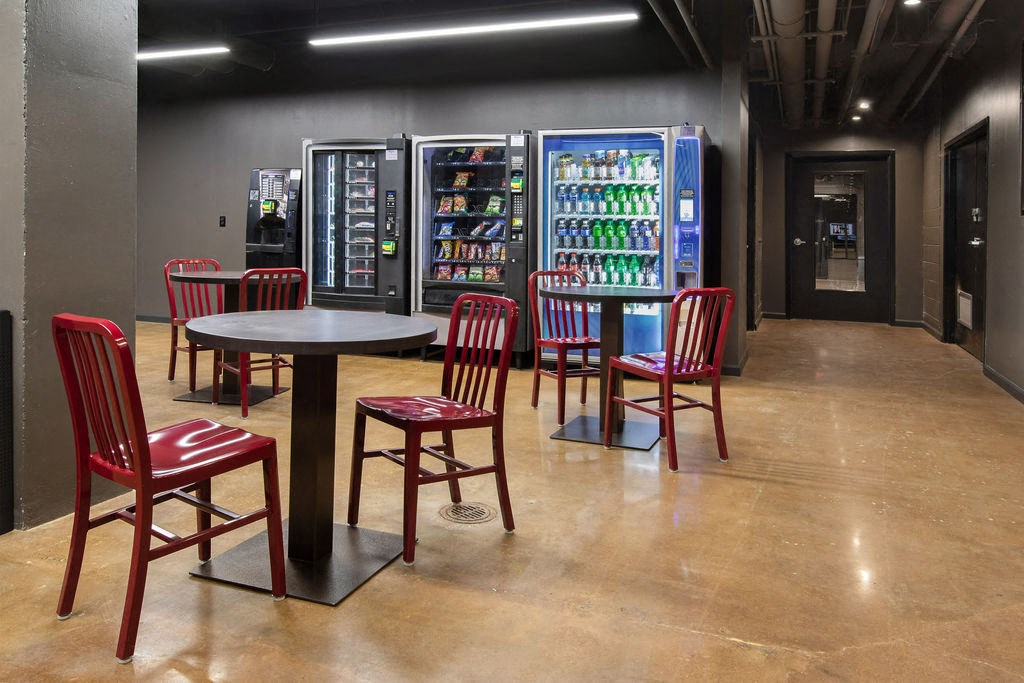 a room with tables and chairs and vending machines