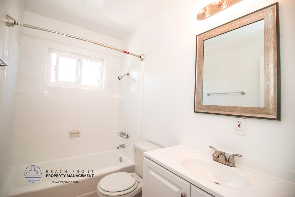 a bathroom with a sink toilet and a mirror and a tub