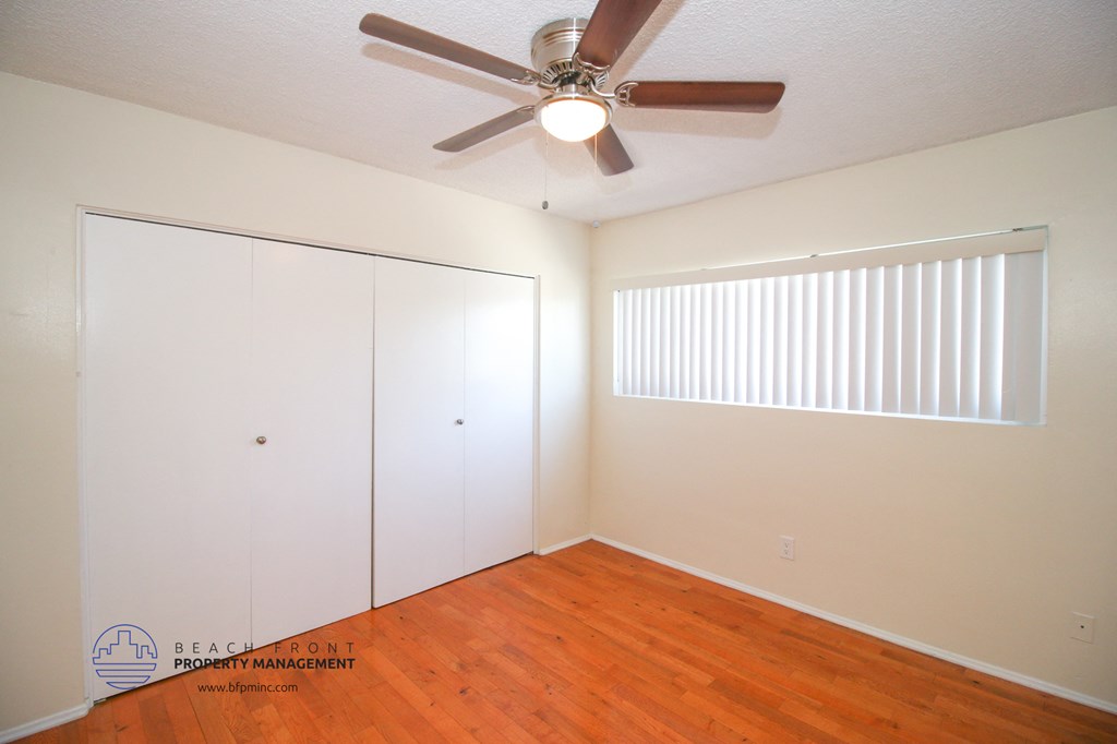 a bedroom with a ceiling fan and a closet