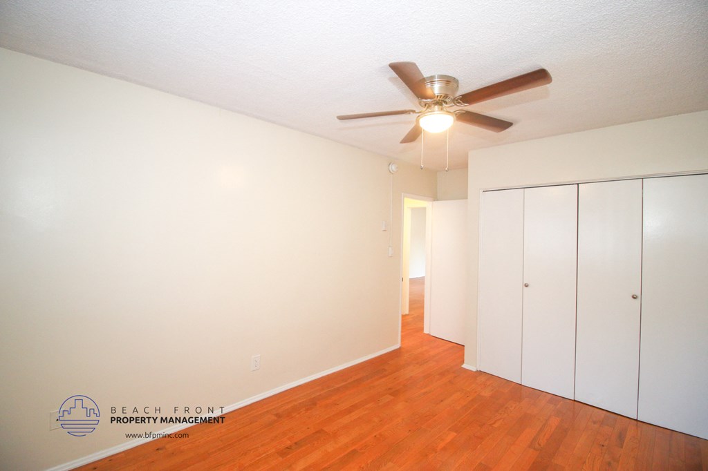 a bedroom with white cabinets and a ceiling fan