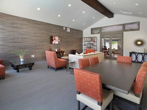 A dining room with a wooden wall and a table with chairs.