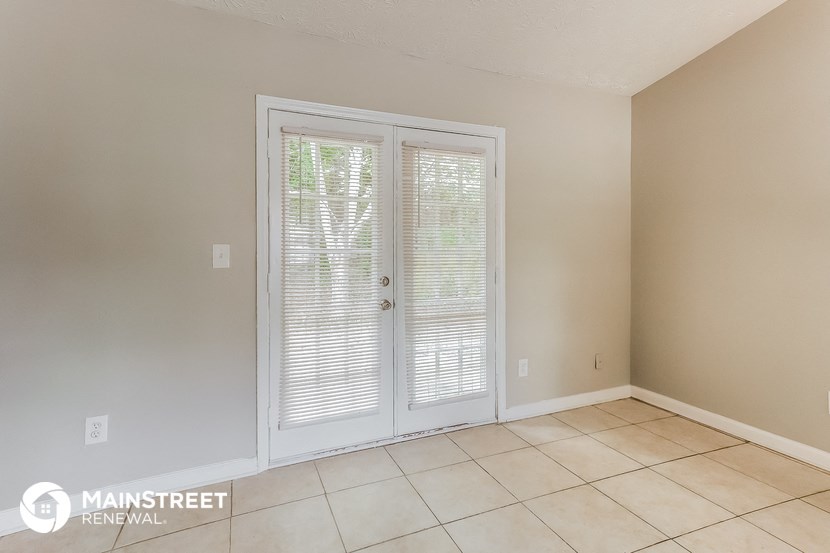 the living room of an empty house with white doors and a tiled floor