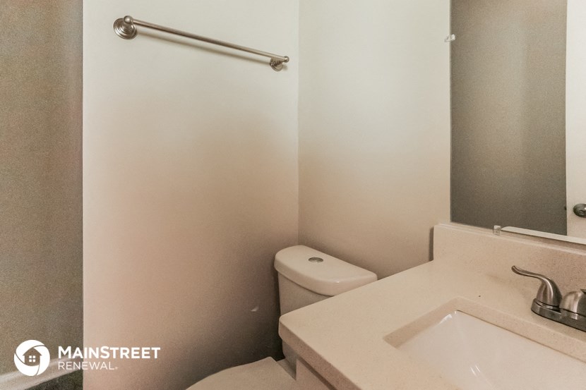 a bathroom with a toilet and a sink and a mirror