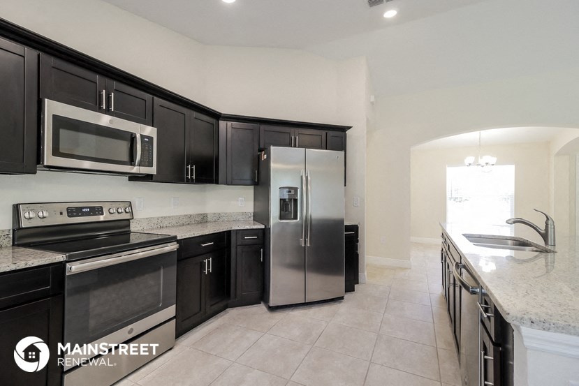 a kitchen with black cabinets and stainless steel appliances and granite counter tops