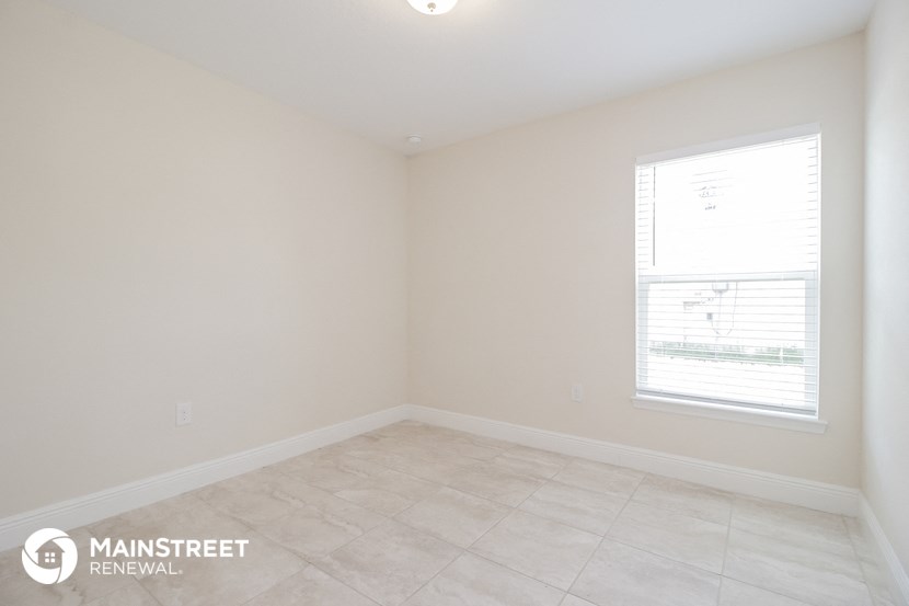 the corner of a room with a window and a tiled floor