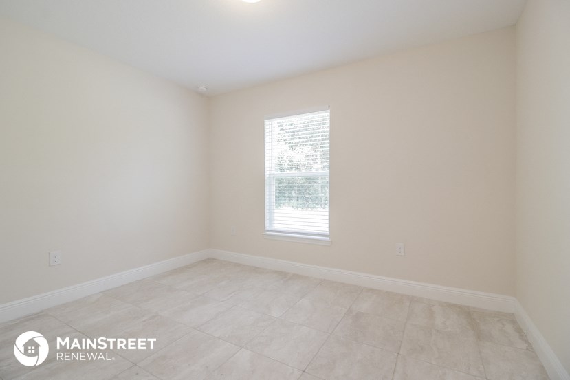 an empty room with white walls and a window