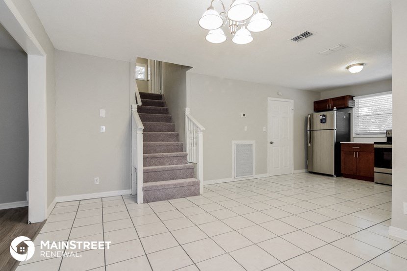 the kitchen and living room with stairs to the upper level
